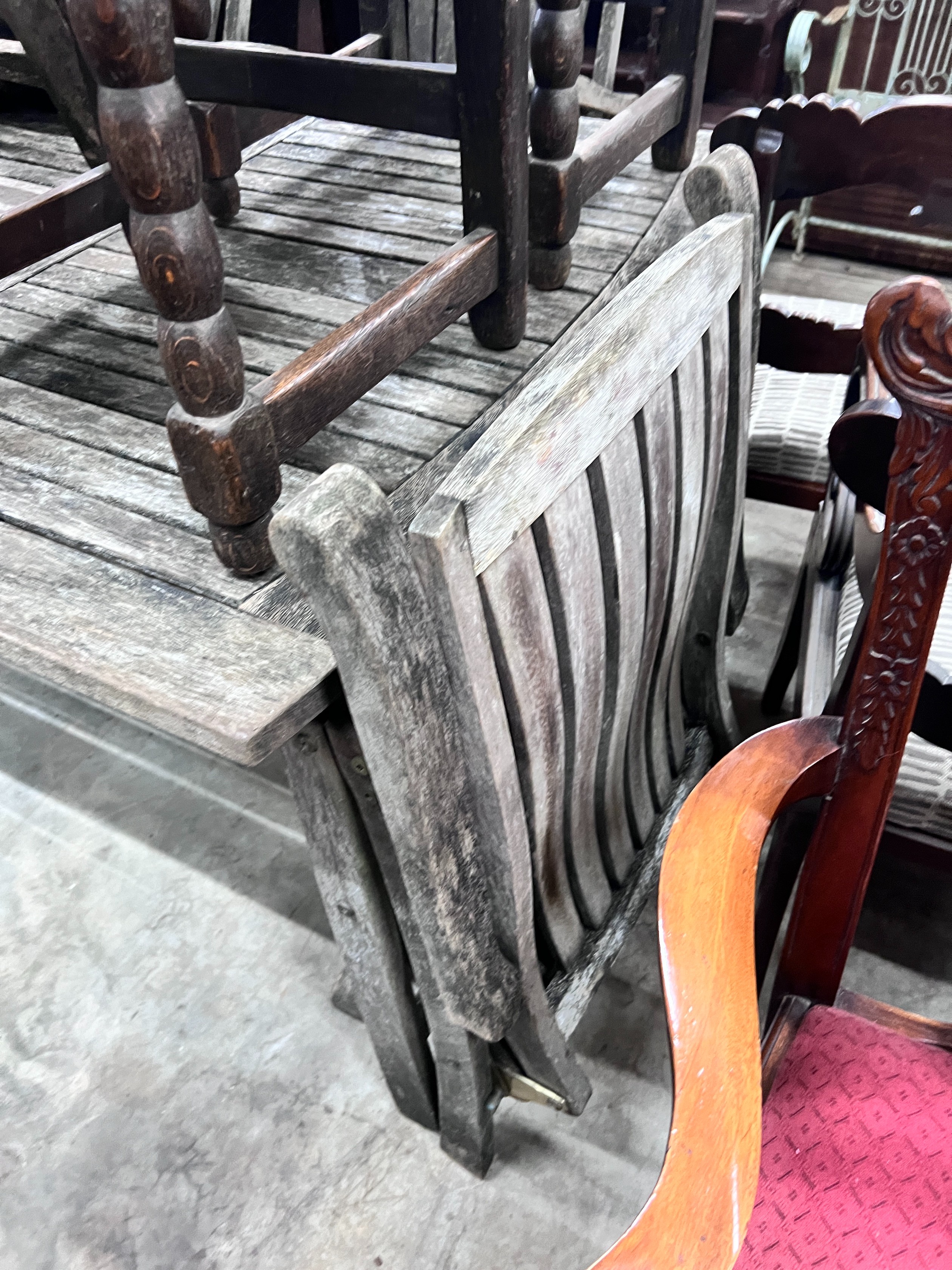 A weathered teak extending garden table with five matching folding armchairs, length 195cm, depth 110cm, height 76cm *Please note the sale commences at 9am.
